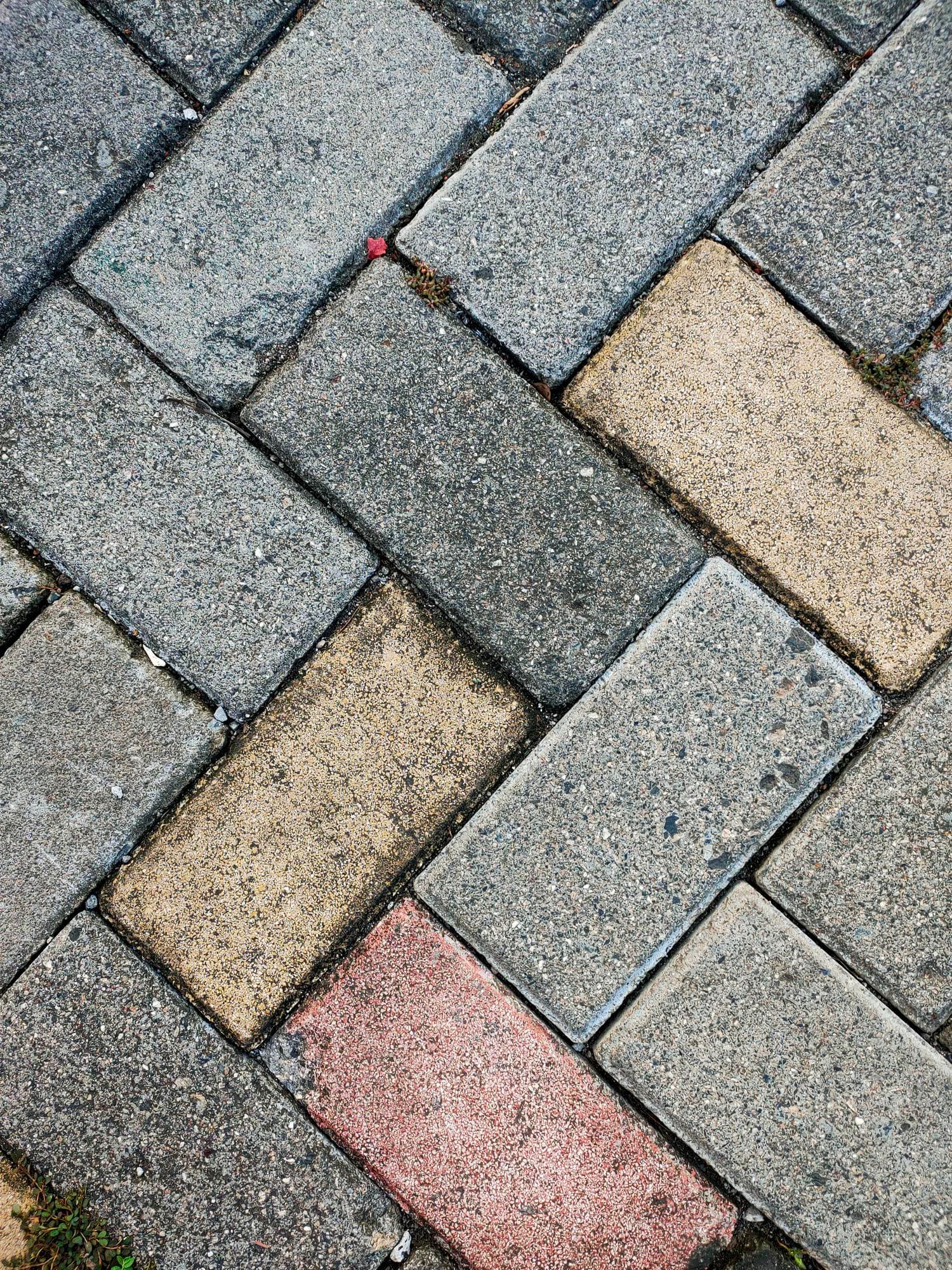 Herringbone paving slabs in grey, buff and red
